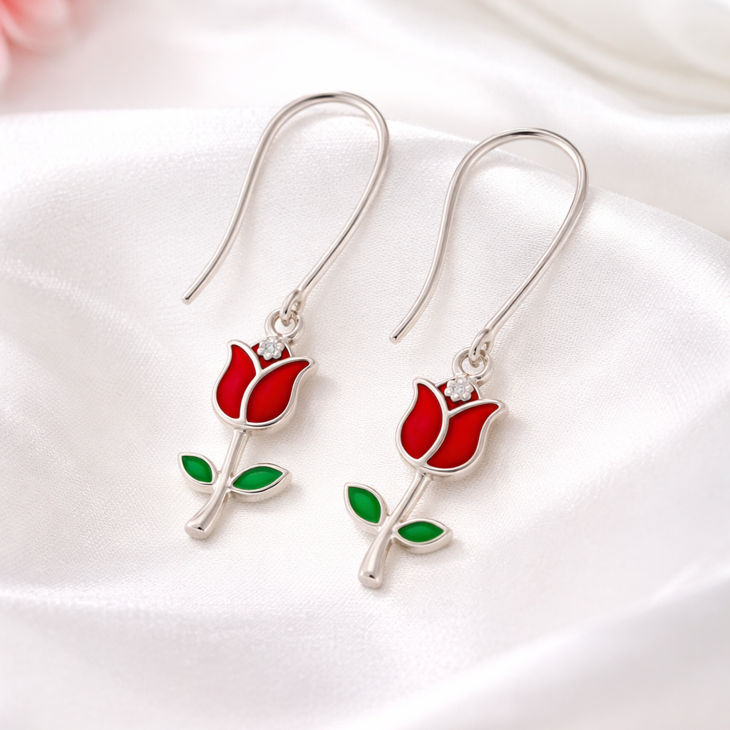 Red rose-shaped earrings on a white satin background