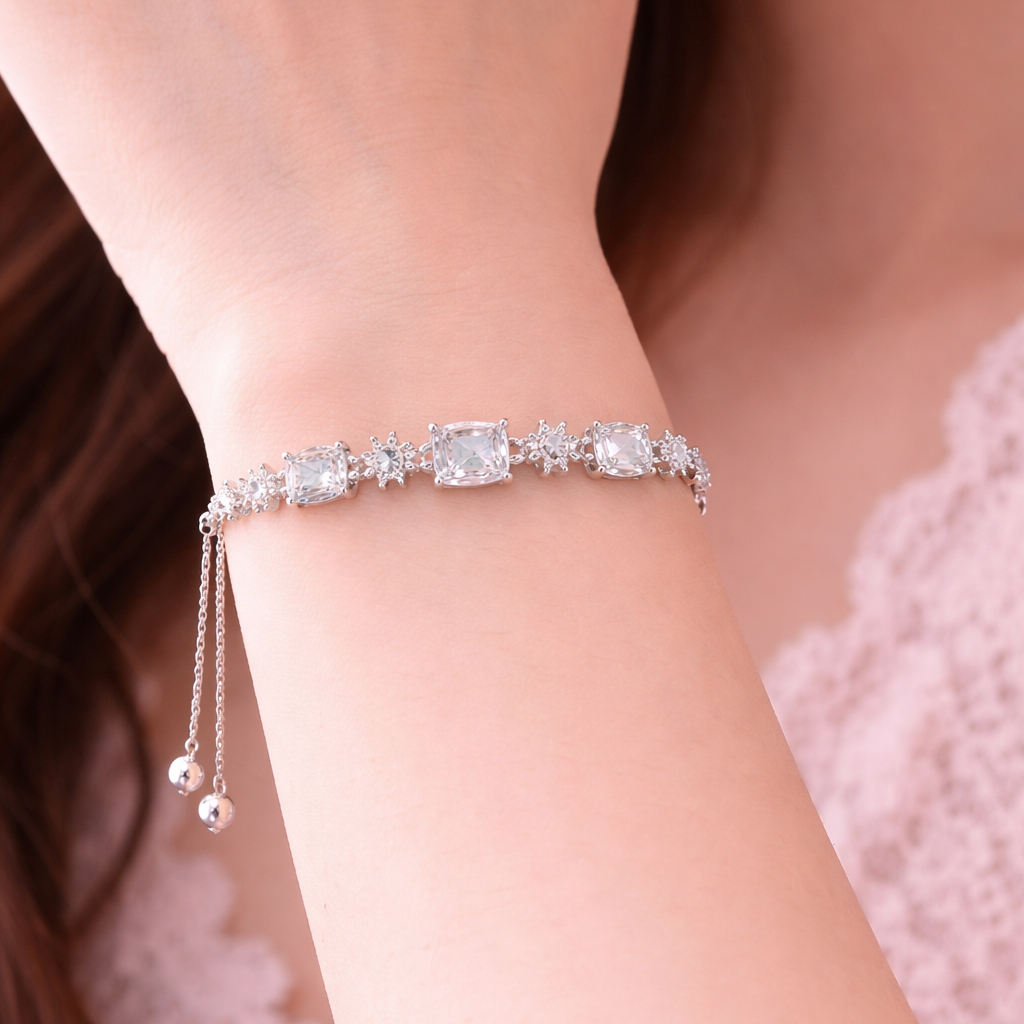Silver bracelet with crystals on a wrist against a blurred background