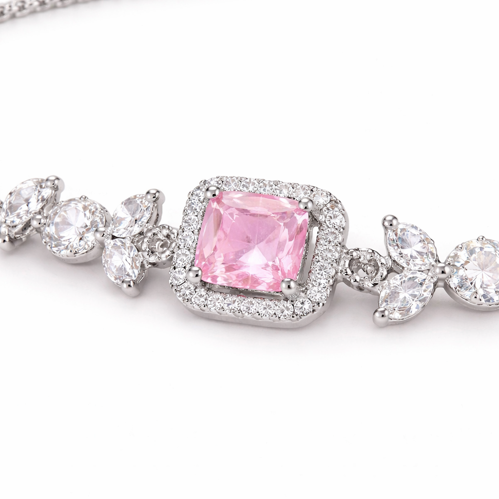 Close-up of a bracelet with a pink gemstone and silver chain on a white background