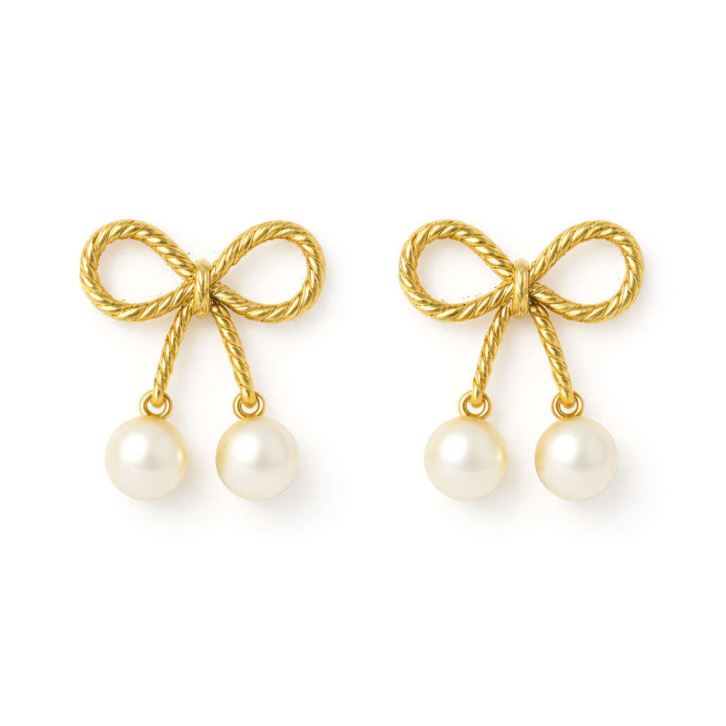 Gold bow-shaped earrings with pearl drops on a white background
